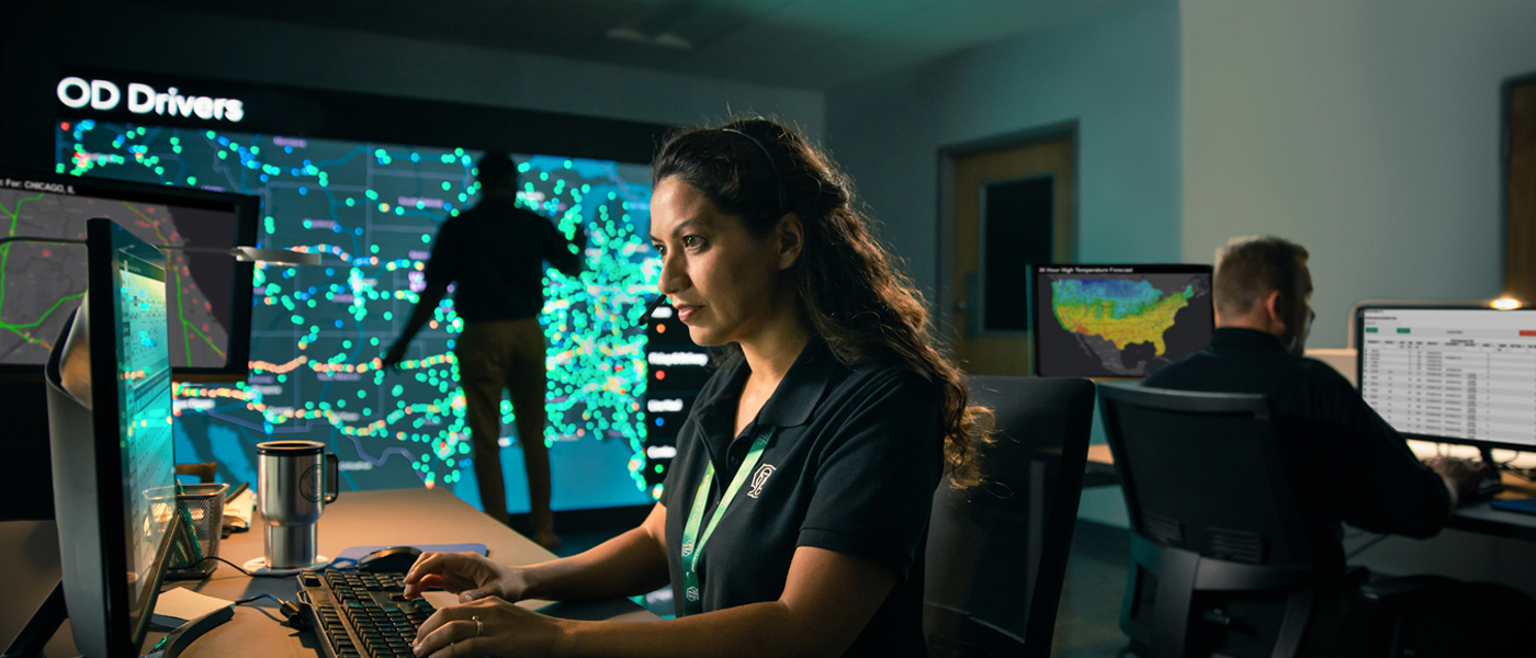 ODFL employee monitoring freight logistics data in a control center with real-time driver tracking.